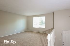 Indianapolis house for rent - a bedroom with a white carpeted floor and a window