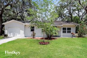 New Port Richey house for rent - a white house with a lawn and trees