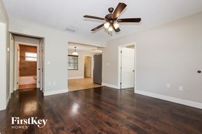 New Port Richey house for rent - the living room and dining room with hardwood flooring and a ceiling fan