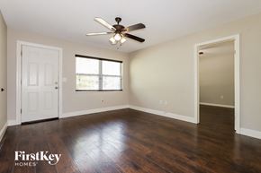 New Port Richey house for rent - an empty living room with hardwood floors and a ceiling fan