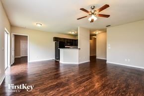 North Port house for rent - an empty living room with a ceiling fan and a kitchen