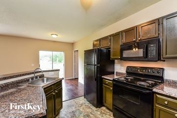 North Port house for rent - a kitchen with black appliances and granite counter tops