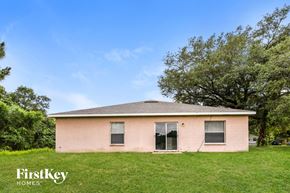 North Port house for rent - a small pink house in a grassy area with trees