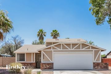 Peoria house for rent - a house with a white garage door and palm trees