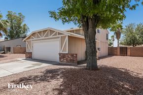 Peoria house for rent - a house with a garage and a tree in front of it