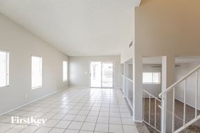 Peoria house for rent - a spacious living room with a tiled floor and a staircase