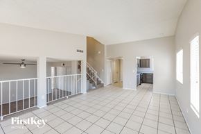 Peoria house for rent - a spacious living room with a white tiled floor and a staircase