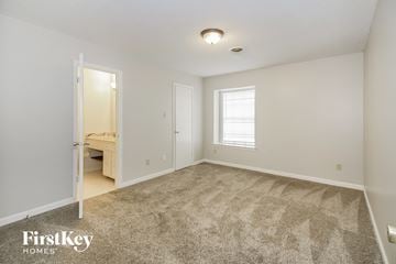 Memphis house for rent - a spacious living room with carpet and a door to a bathroom
