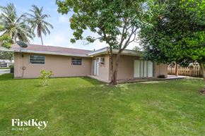 Plantation house for rent - A house with a lawn and trees in front of it.