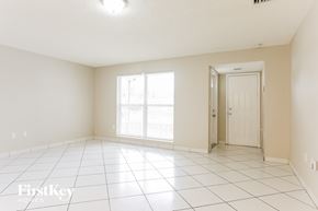 Sunrise house for rent - A spacious empty room with a door and a window.