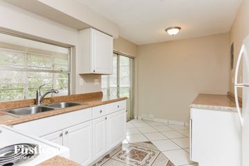 Sunrise house for rent - A kitchen with white cabinets and a sink.