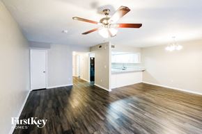 Hialeah house for rent - an empty living room with a ceiling fan and a kitchen