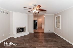 Bartlett house for rent - a living room with a ceiling fan and a fireplace
