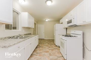 Indianapolis house for rent - A kitchen with white appliances and cabinets.