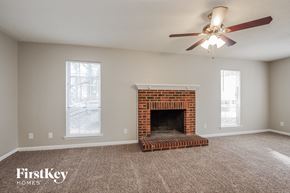 Charlotte house for rent - A room with a fireplace and a ceiling fan.