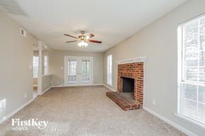 Charlotte house for rent - A spacious living room with a fireplace and a ceiling fan.