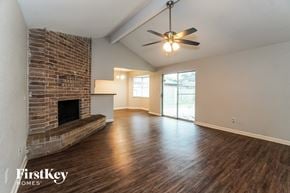 Houston house for rent - A room with a brick fireplace and wooden floors.