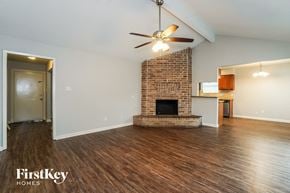 Houston house for rent - A room with a brick fireplace and a ceiling fan.