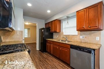 Houston house for rent - A kitchen with wooden cabinets and a black dishwasher.