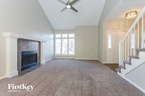 Parkville house for rent - an empty living room with a fireplace and a staircase