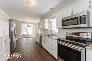 Parkville house for rent - a kitchen with white cabinets and stainless steel appliances