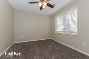 Parkville house for rent - the bedroom with carpet and a ceiling fan and a window