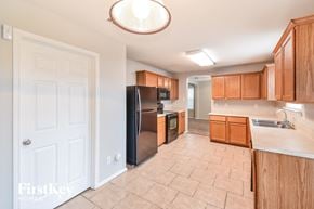 San Antonio house for rent - a kitchen with wooden cabinets and a stainless steel refrigerator