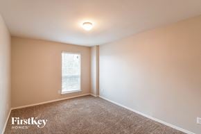 San Antonio house for rent - the upstairs bedroom has a large window and beige walls and carpet