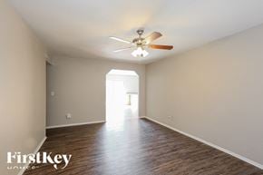 Peoria house for rent - A spacious room with a ceiling fan and wooden flooring.