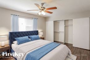 Peoria house for rent - A bedroom with a blue headboard and a white bed.
