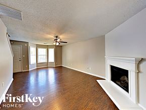 Lithonia house for rent - an empty living room with a fireplace and a ceiling fan