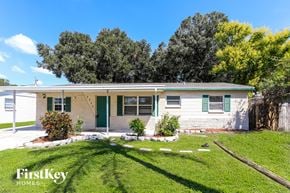 Pinellas Park house for rent - a small white house with green shutters and a grassy yard