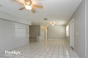 Pinellas Park house for rent - an empty living room with a ceiling fan and a tile floor