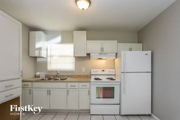 Pinellas Park house for rent - a kitchen with white appliances and white cabinets