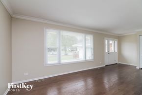 Naperville house for rent - the living room of a home with a large window and wooden floors