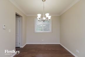 Naperville house for rent - a empty dining room with a window and a chandelier