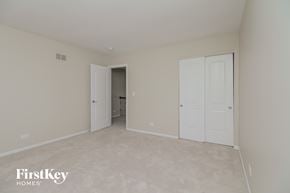 Naperville house for rent - a bedroom with two closets and a door to a hallway