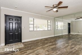 Pembroke Pines house for rent - the living room has a large mirror and a ceiling fan