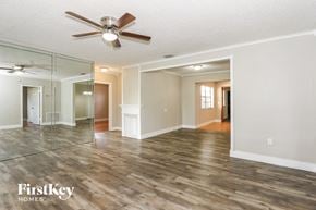 Pembroke Pines house for rent - an empty living room with a ceiling fan and a large mirror