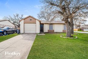 Fort Worth house for rent - a white house with a driveway and a tree in the yard
