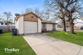Fort Worth house for rent - a small white house with a garage and a driveway