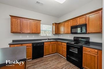 Charlotte house for rent - a kitchen with black appliances and wooden cabinets