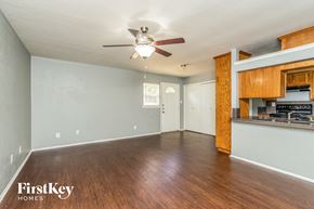 Fort Worth house for rent - an empty living room with wood flooring and a ceiling fan