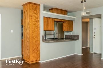 Fort Worth house for rent - a kitchen with wooden cabinets and a counter top and a sink
