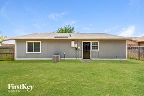 Fort Worth house for rent - the front of a gray house with a grassy yard