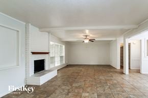 Spring house for rent - A spacious room with a fireplace and tiled flooring.