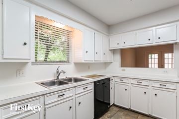 Spring house for rent - A kitchen with white cabinets and a black dishwasher.