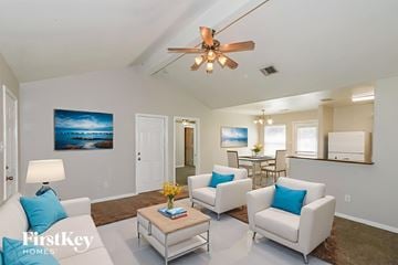 Richmond house for rent - A living room with a ceiling fan and a painting of a beach scene on the wall.