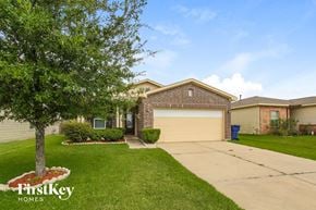 Baytown house for rent - A house with a garage and a tree in front of it.