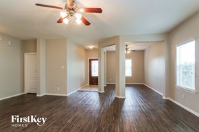 Baytown house for rent - A spacious room with wooden floors and a ceiling fan.